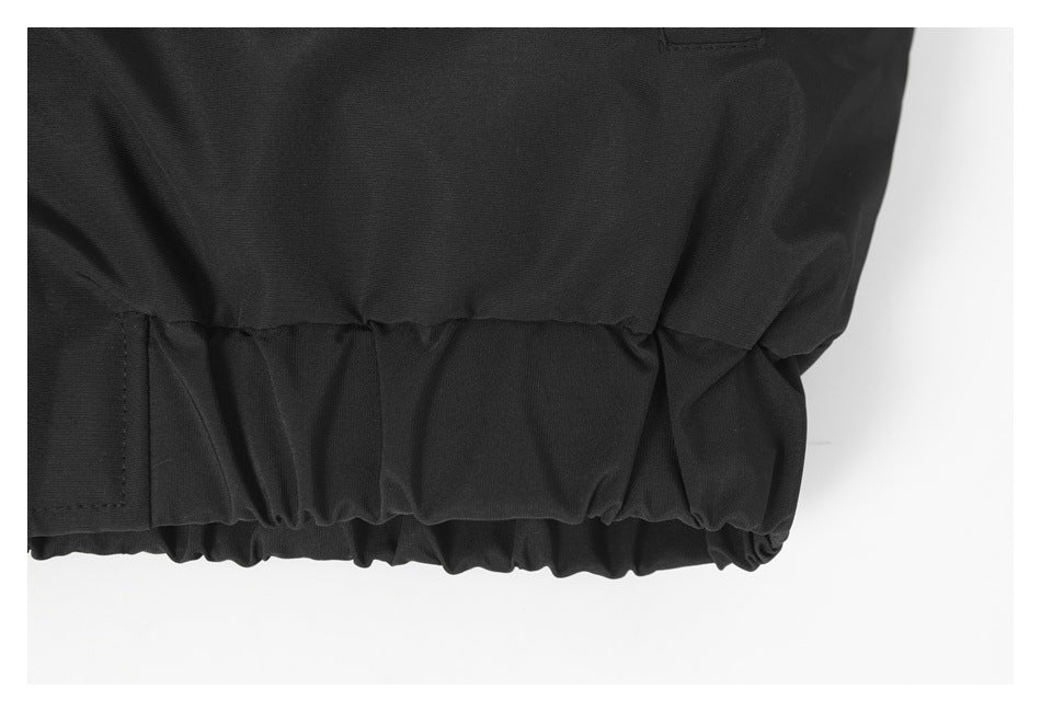 Close-up of the gathered elastic hem on a black jacket.