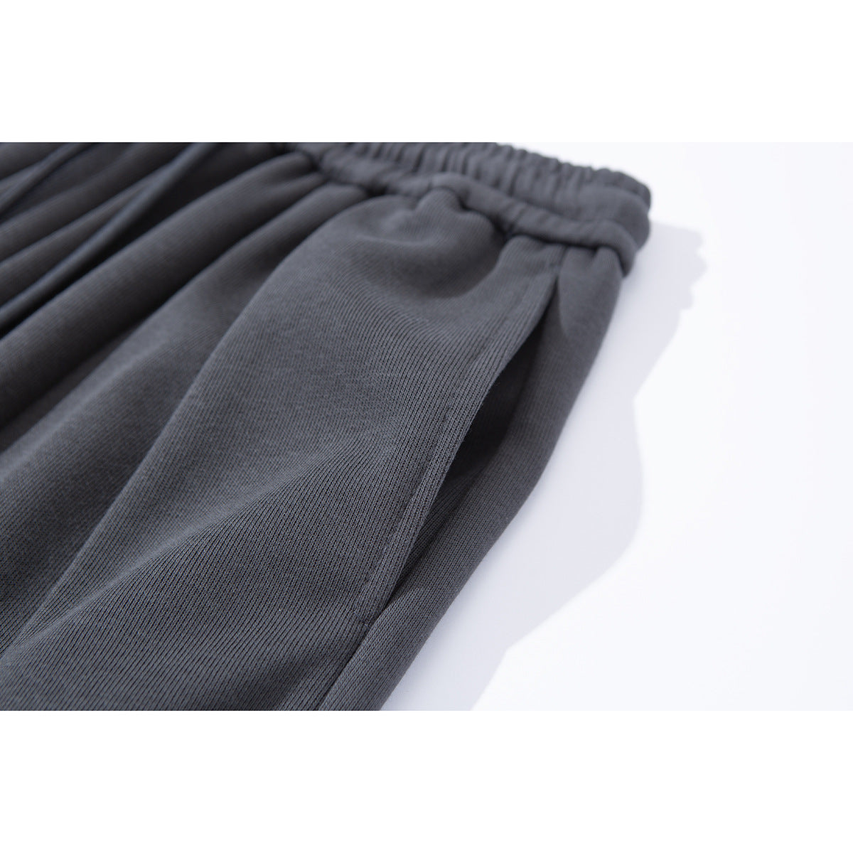 Angled close-up of charcoal pants showing the elastic waist and fabric texture.