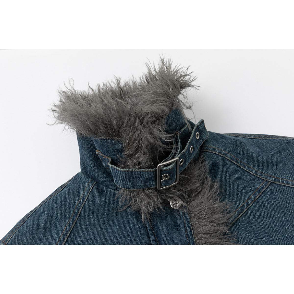 Close-up of the jacket's gray shaggy collar, denim strap and metal buckle.