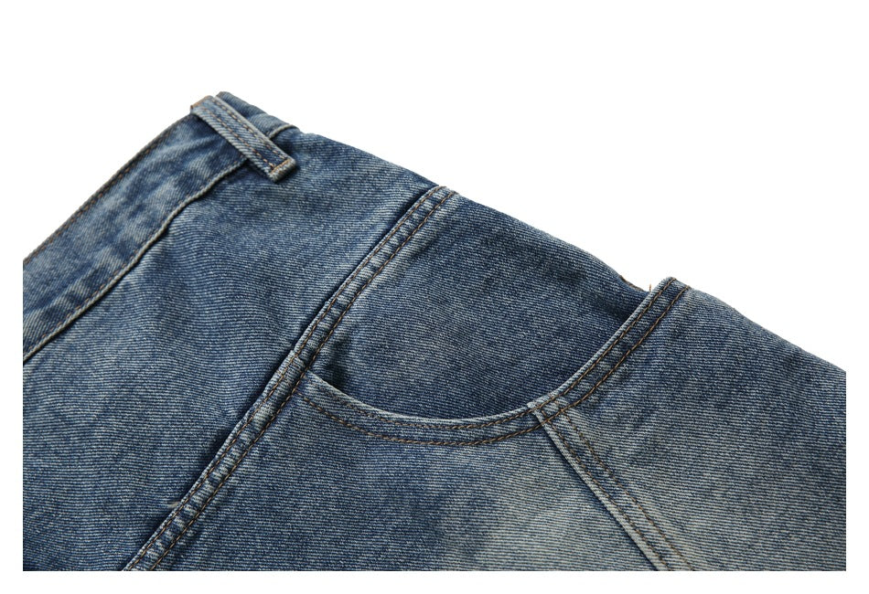 Close-up of a blue denim shorts front pocket and waistband with contrast stitching.