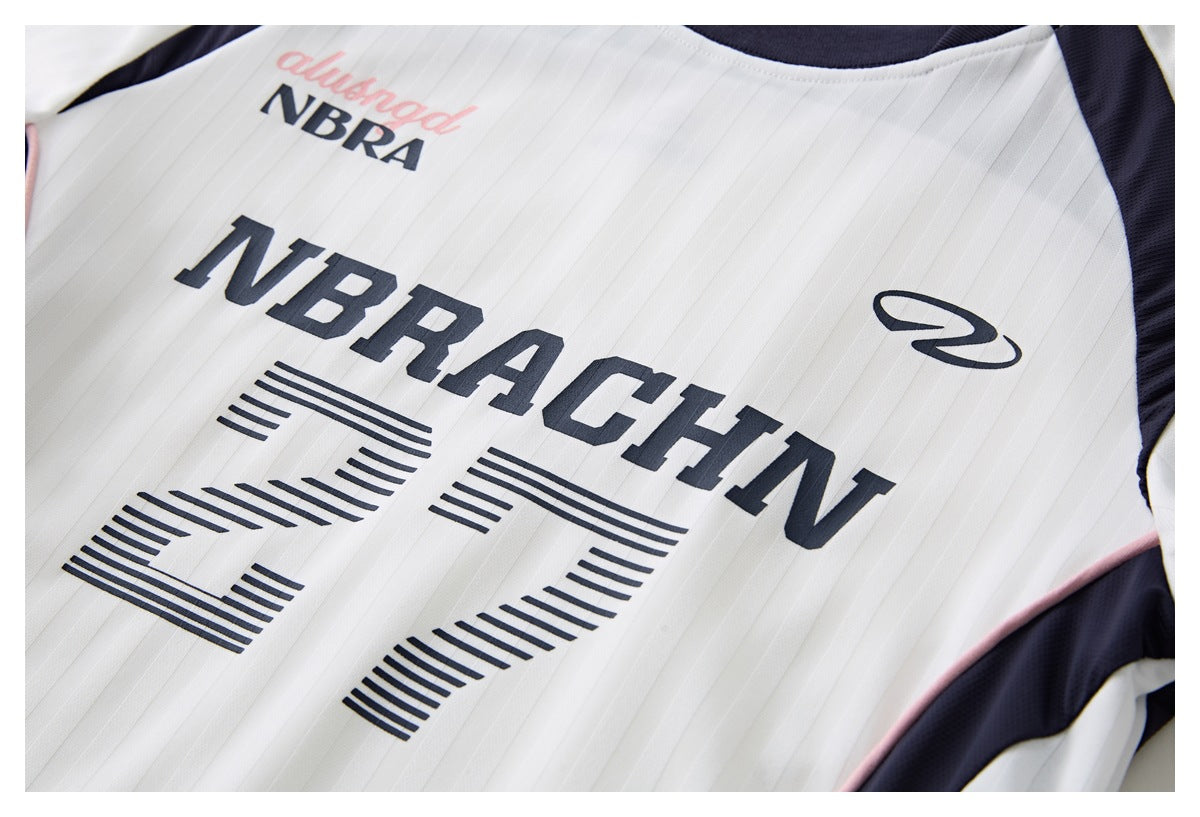 Close-up of the white jersey front with navy lettering, a striped number 27, and navy panels edged in pink.