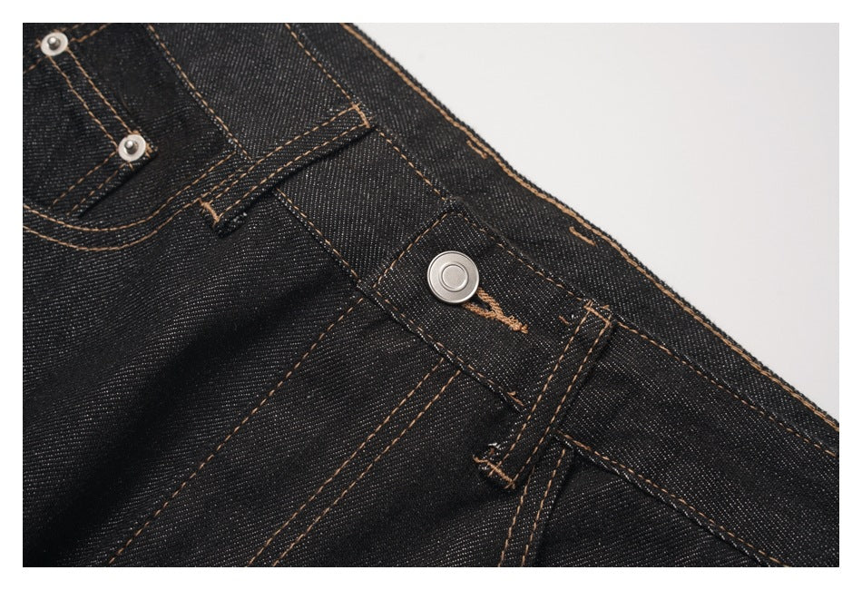 Close-up of the jeans' metal waist button, belt loop, and contrast-stitched dark denim waistband.