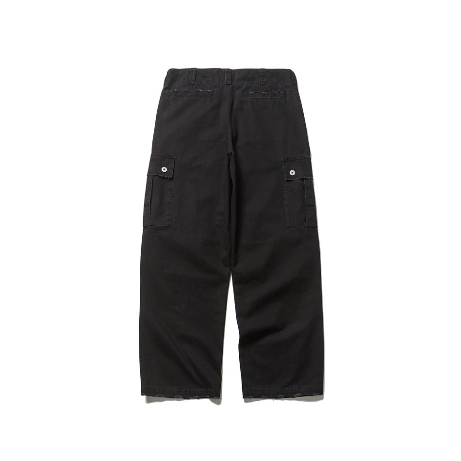 Back view of black cargo trousers with two rear welt pockets and buttoned side cargo pockets.