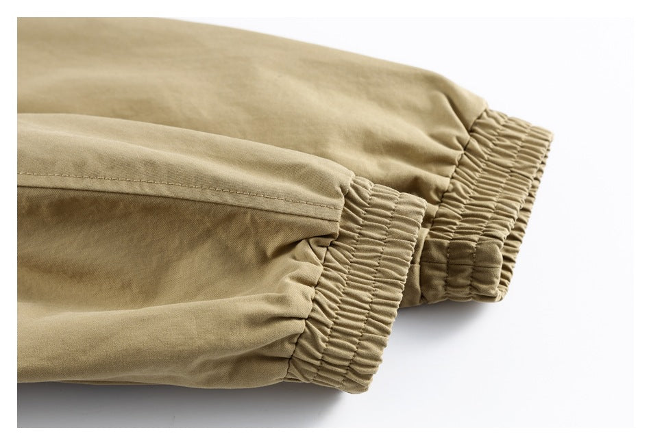 Close-up of two beige garment cuffs with gathered elastic hems and stitching.