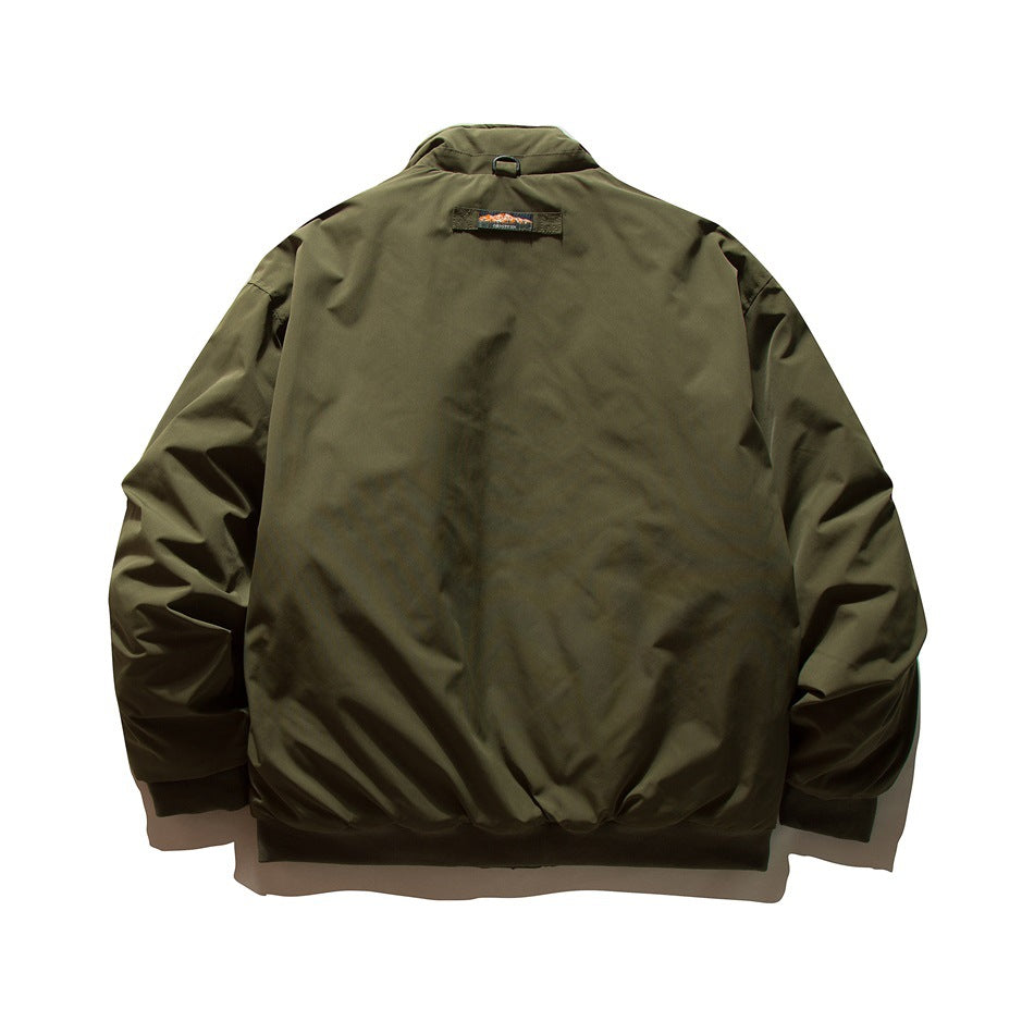 Back view of an olive green jacket with a stand collar, elastic cuffs and hem, and a small patch below the collar.
