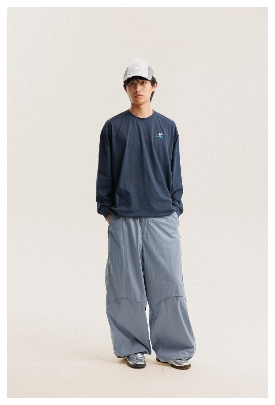 Front view of a model wearing a navy long-sleeve crewneck shirt and pale blue wide-leg pants.