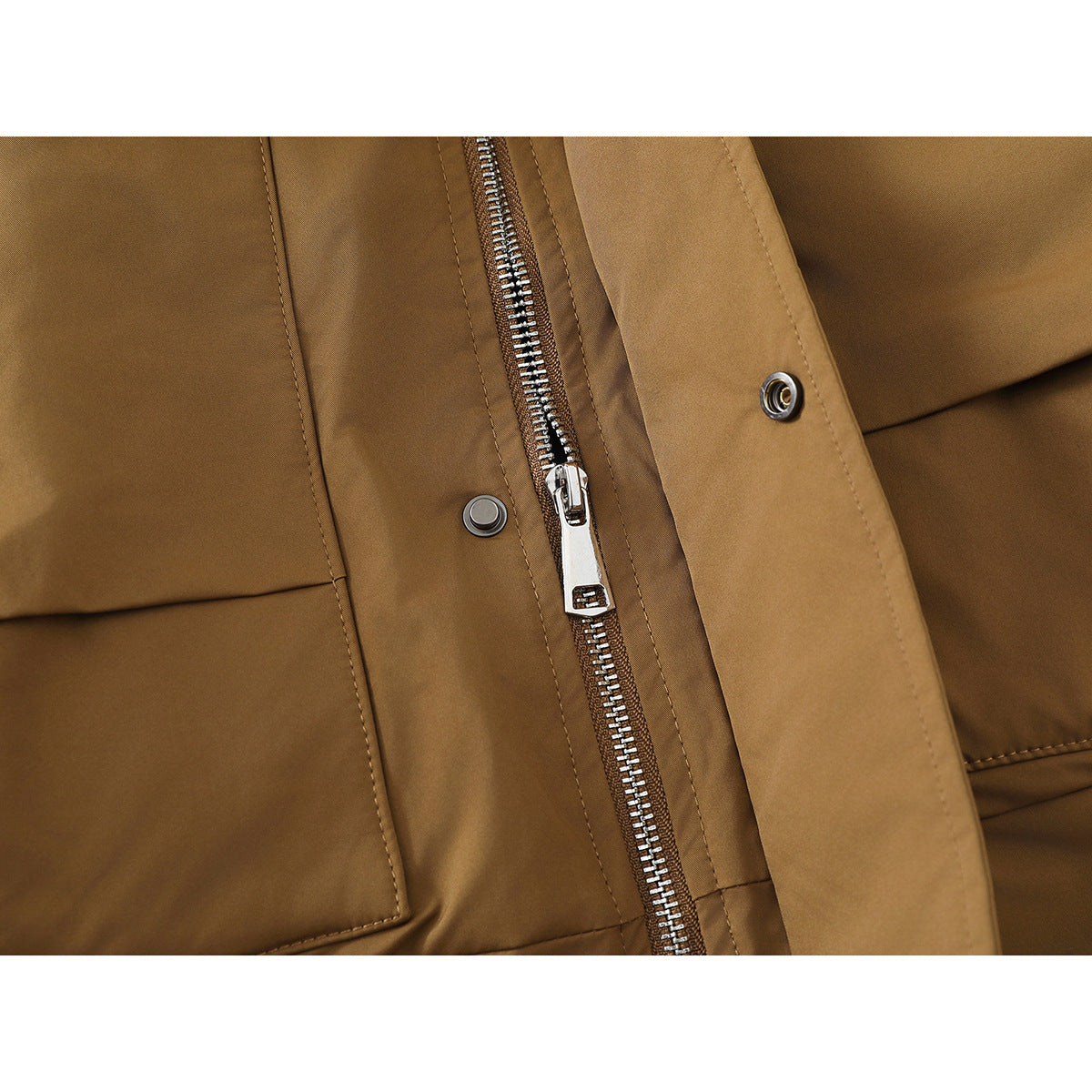 Close-up of a camel-brown jacket's silver zipper and snap-fastened storm flap.