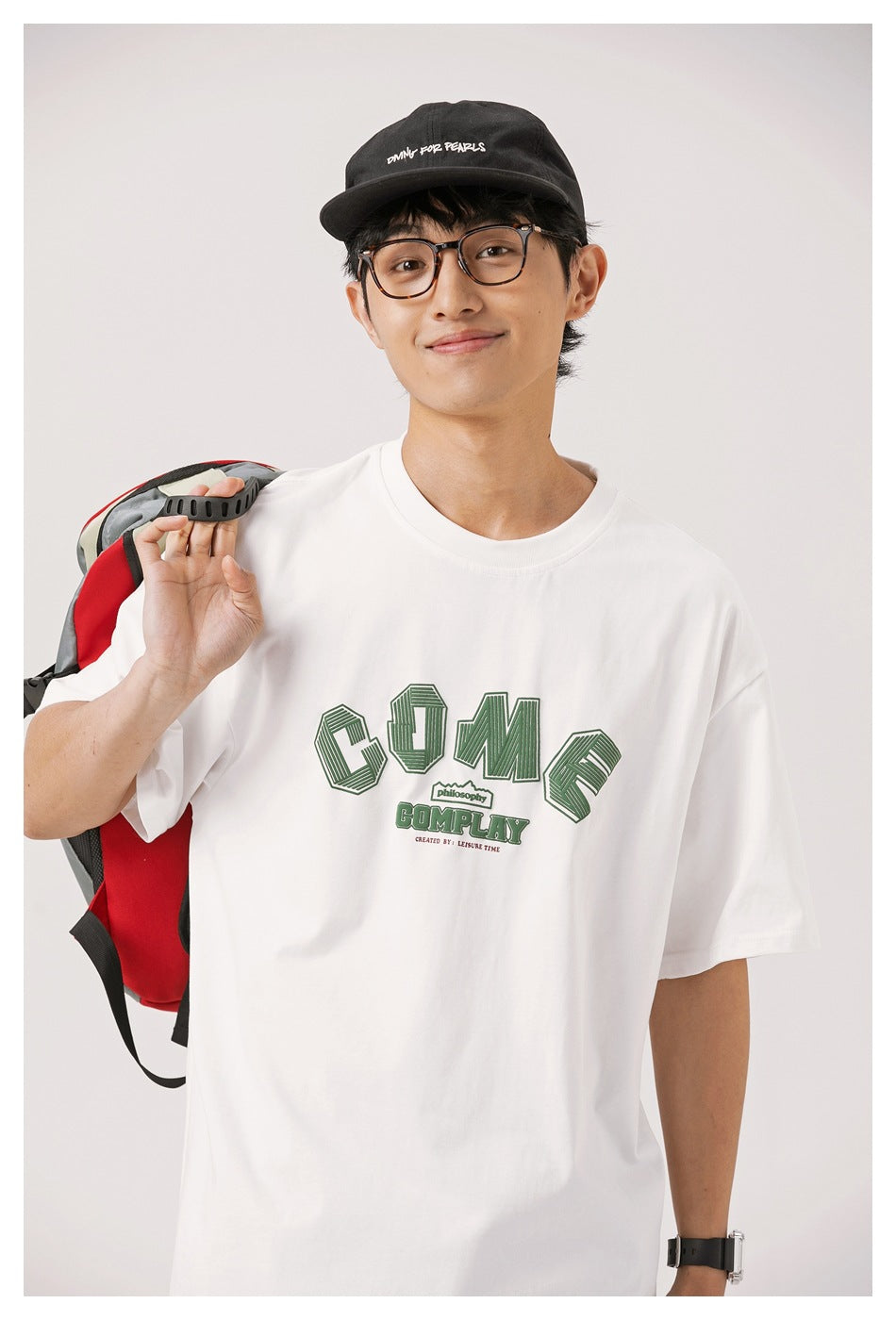 Man modeling a white oversized T-shirt with a large green outlined chest graphic.
