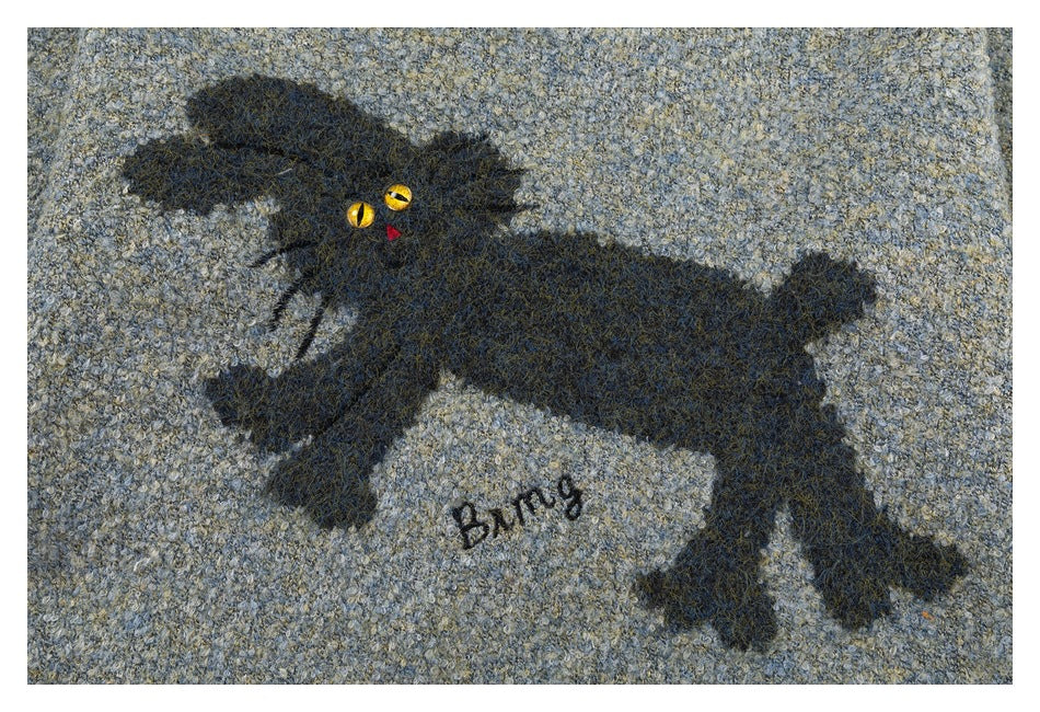 Close-up of a black cat motif with yellow eyes, a red nose, and the word “Bing” embroidered on marled fabric.