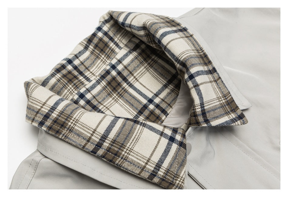 Close-up of a light gray garment collar with beige, navy, and brown plaid lining.