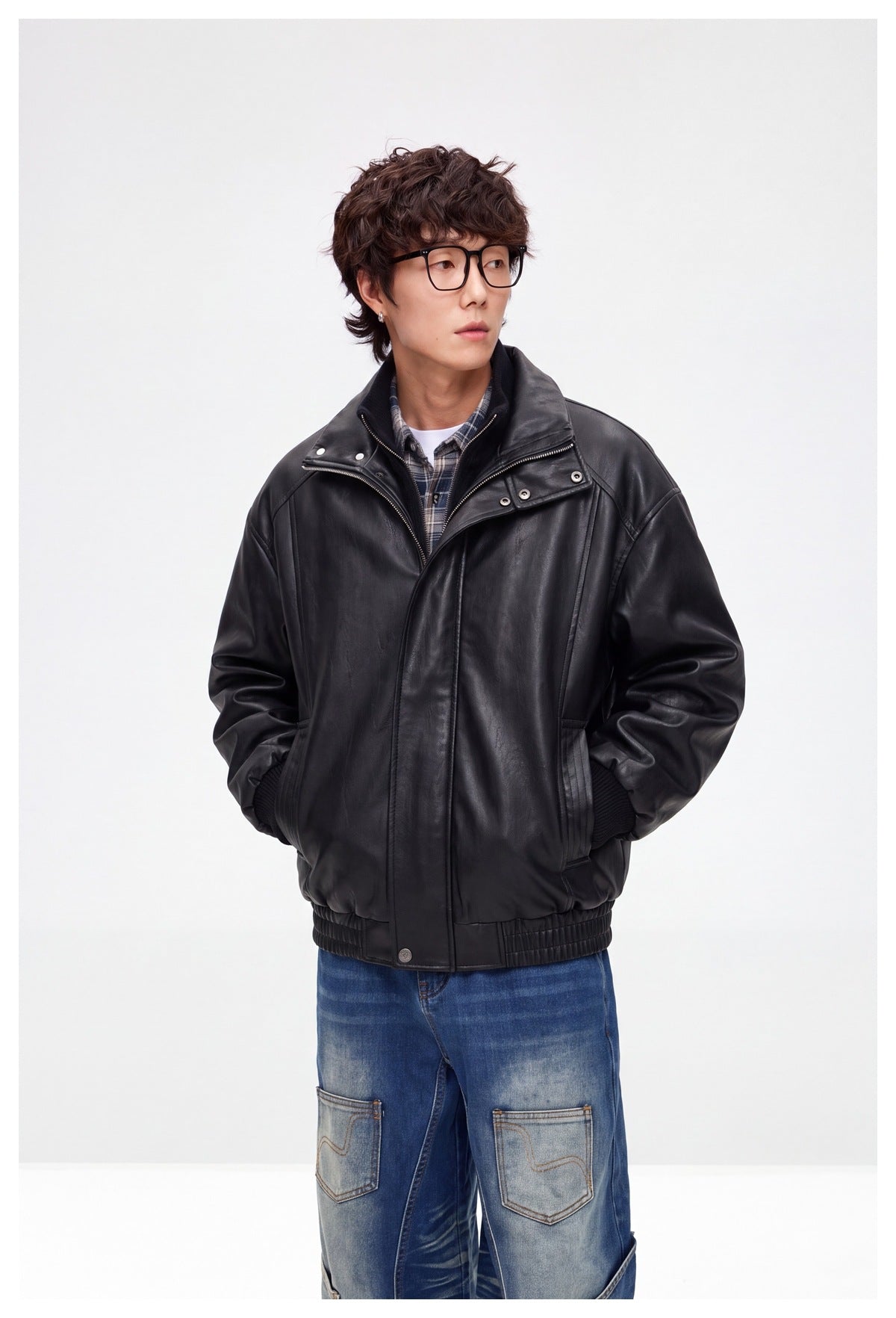 Front view of a model wearing a black leather-look jacket with a wide high collar, snap details, and elastic cuffs and hem.