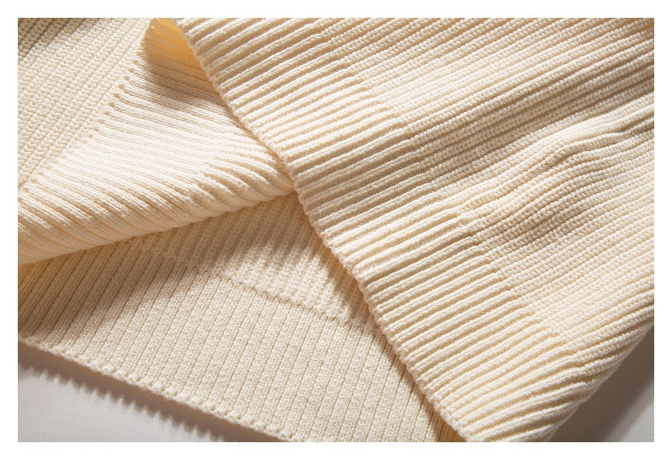 Folded ivory knit showing a wide ribbed edge and contrasting knit textures.