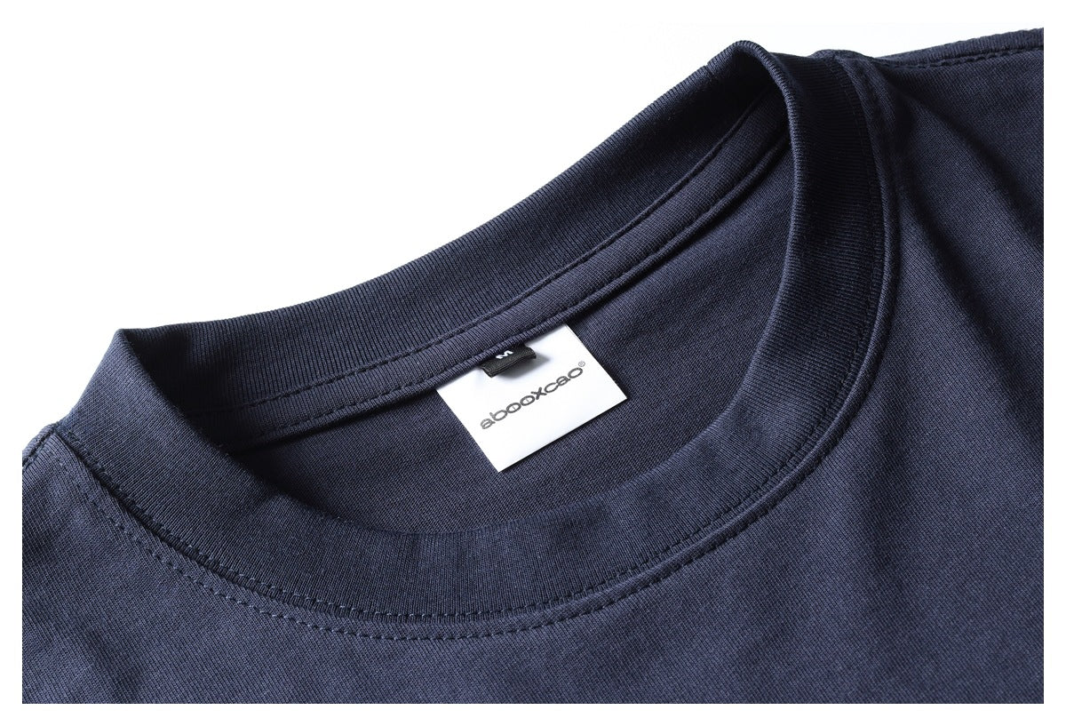 Close-up of a navy T-shirt's crew neck, seam stitching, and inner brand label.