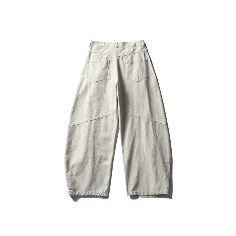 Back view of light beige wide-leg trousers with two patch pockets and curved seam details across the legs.