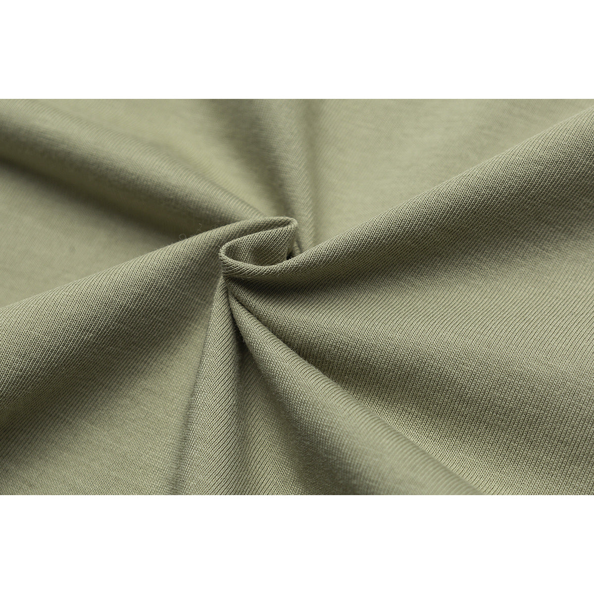 Close-up of olive-green fabric gathered into folds, showing its surface texture.