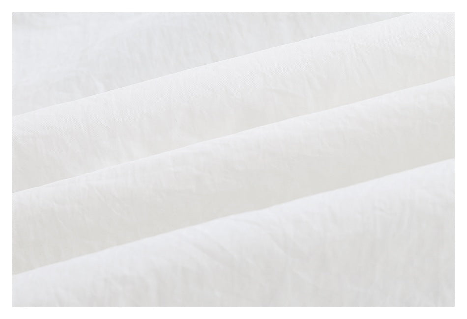 Close-up of white fabric layers and a broad stitched seam.