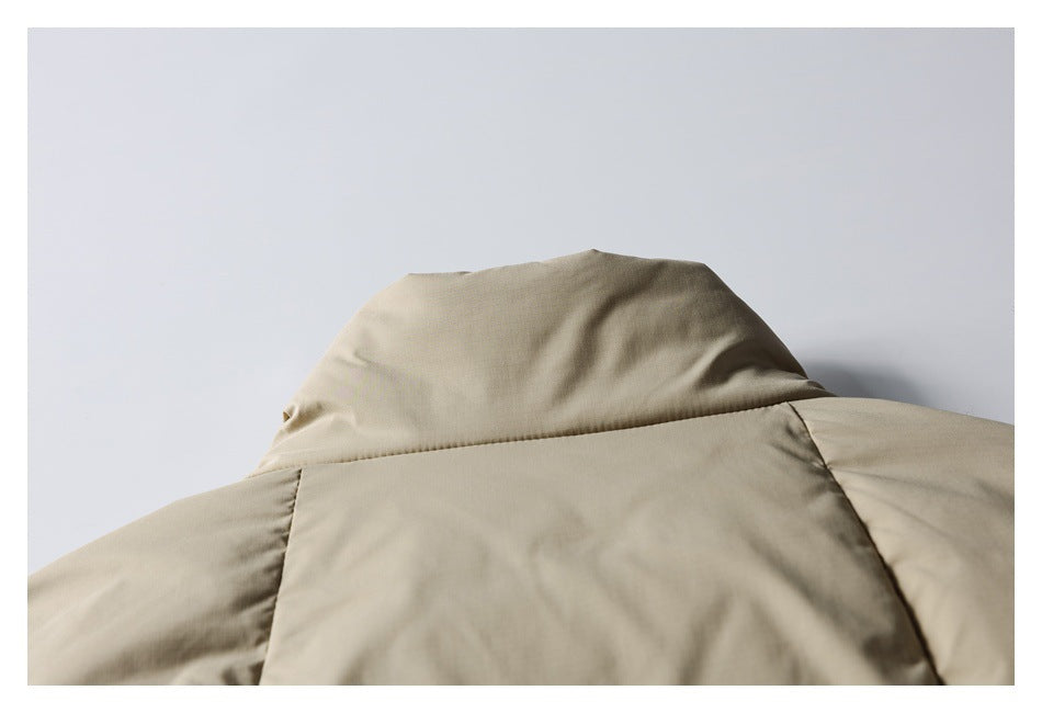 Close-up of a beige padded jacket's raised collar and shoulder seams.