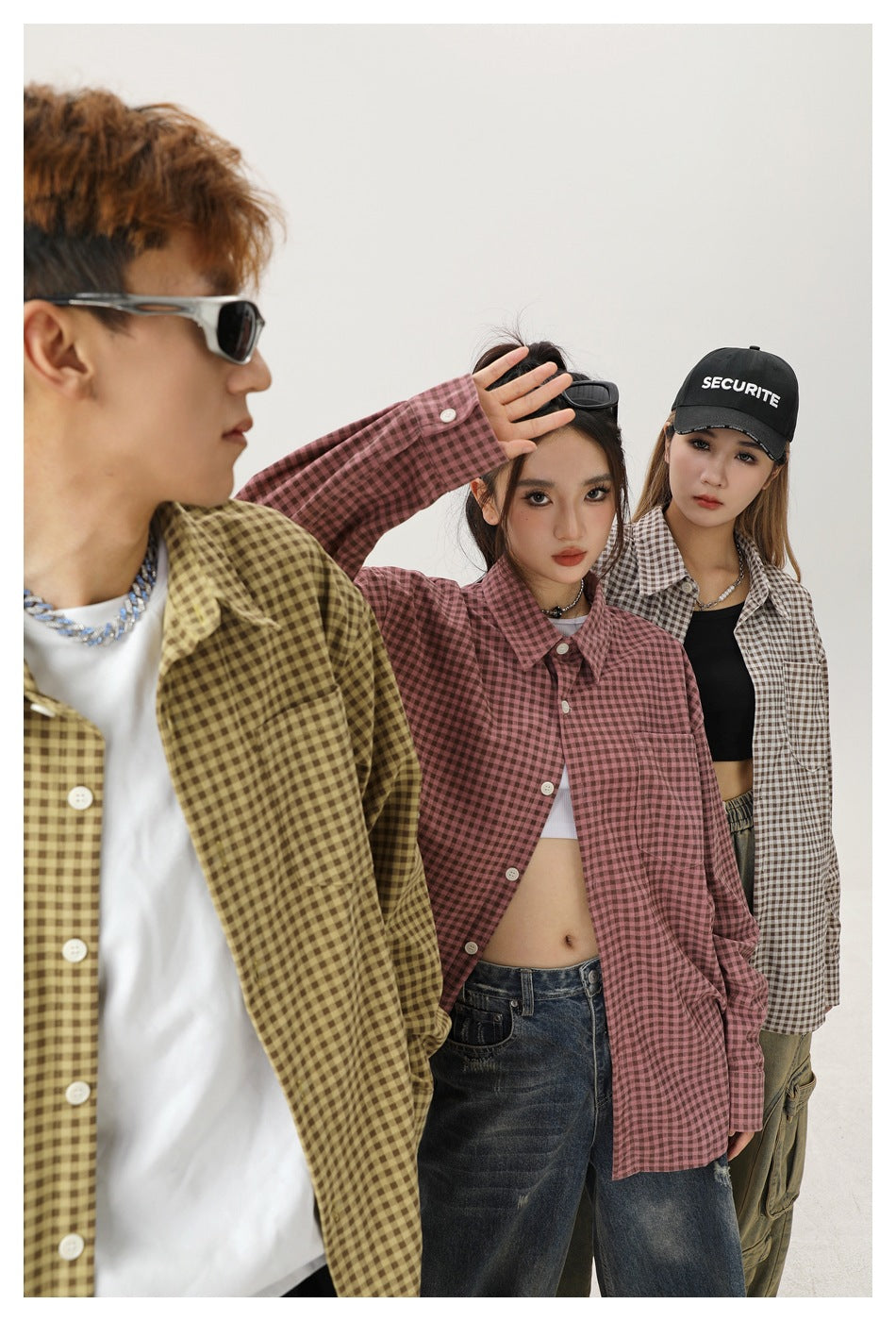 Close studio shot of three models in olive, dusty red and beige gingham long-sleeve shirts