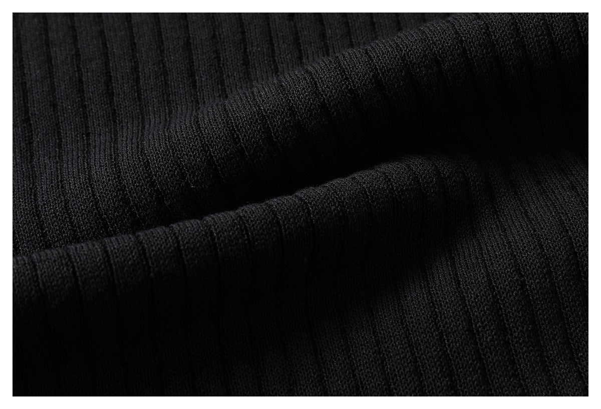 Close-up of folded black knit fabric showing fine vertical ribbing and its texture.