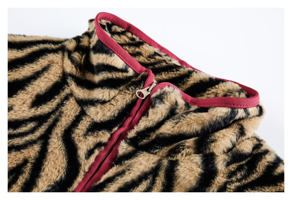 Close-up of a tan-and-black tiger-striped fuzzy garment with a burgundy zipper and matching edge trim.