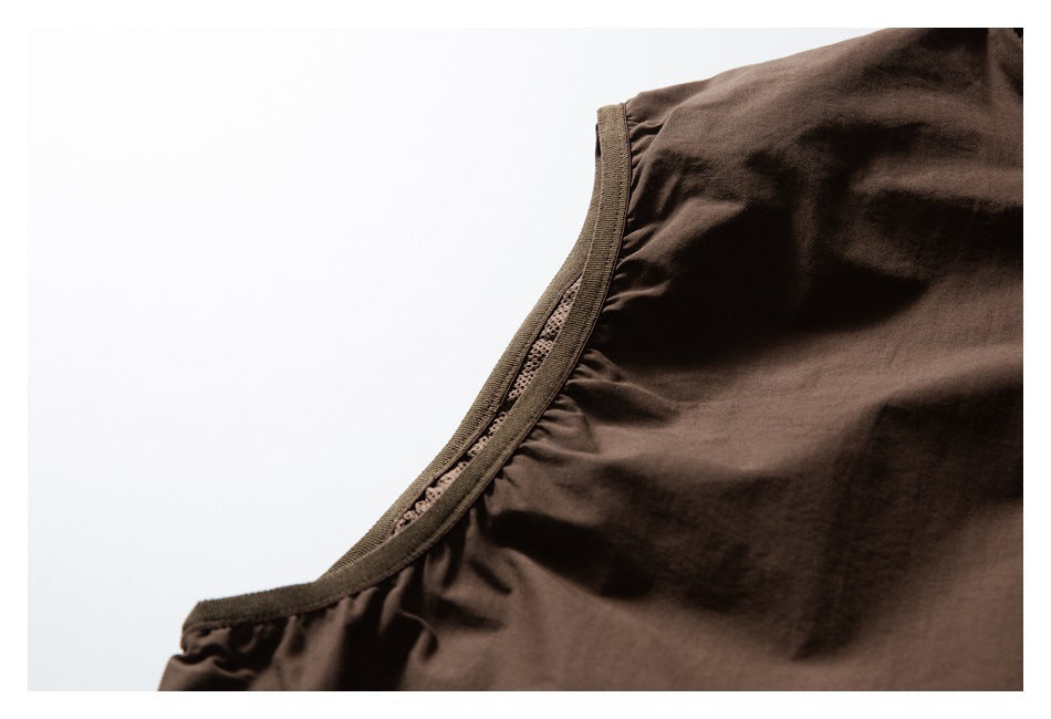 Close-up of brown vest armhole binding and stitching.
