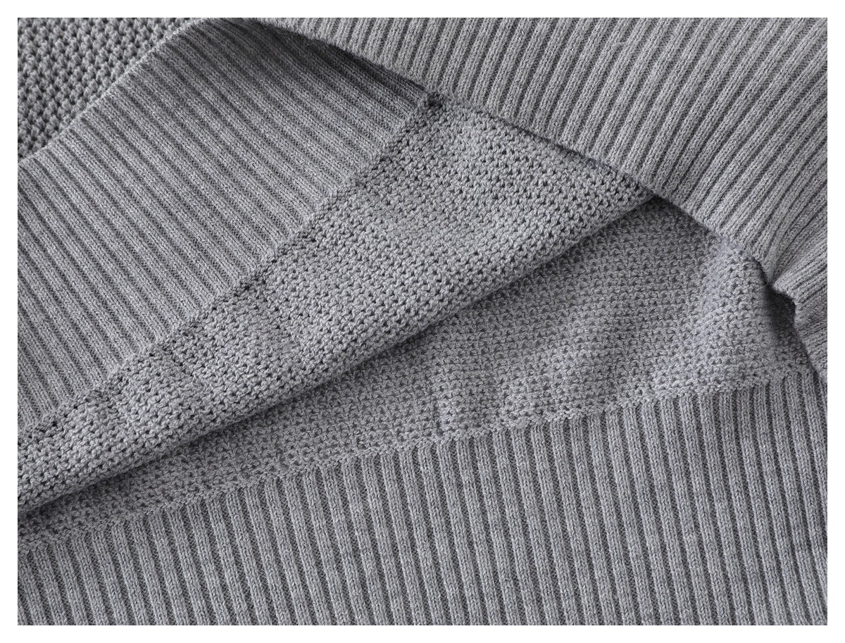 Close-up showing the gray sweater's textured knit and ribbed hem and cuff construction.