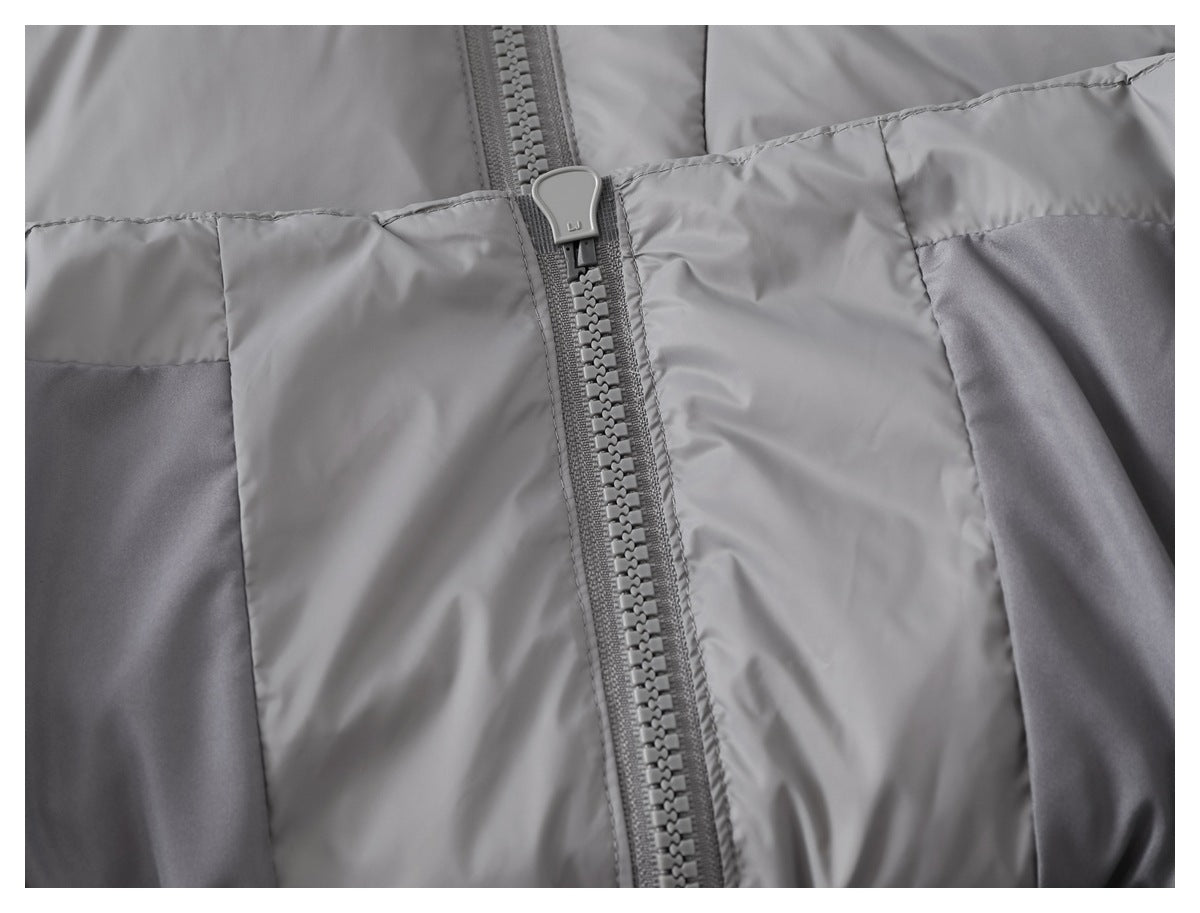 Close-up of a gray color-block jacket front with a chunky center zipper and stitched panels.