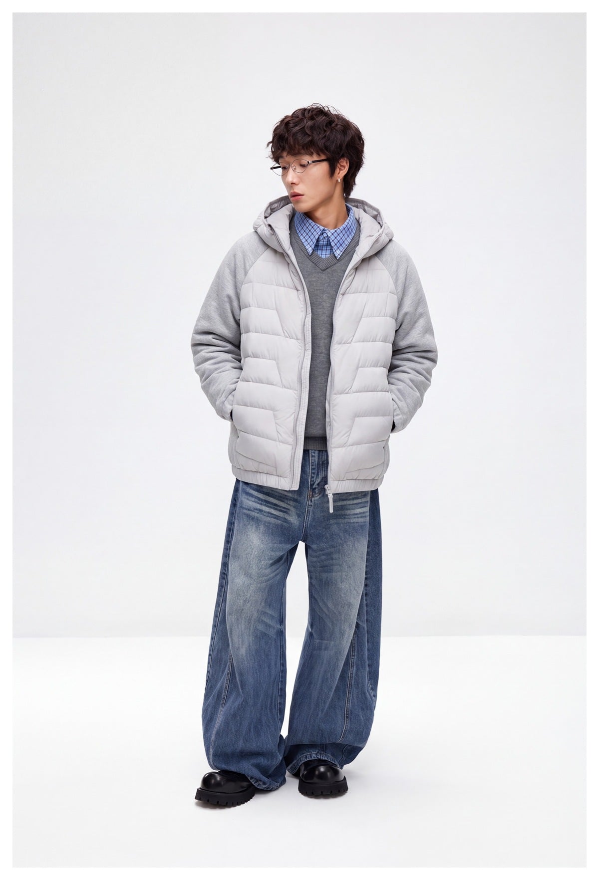 Full-length model wearing the light gray quilted hooded jacket with heather gray sleeves and blue jeans.