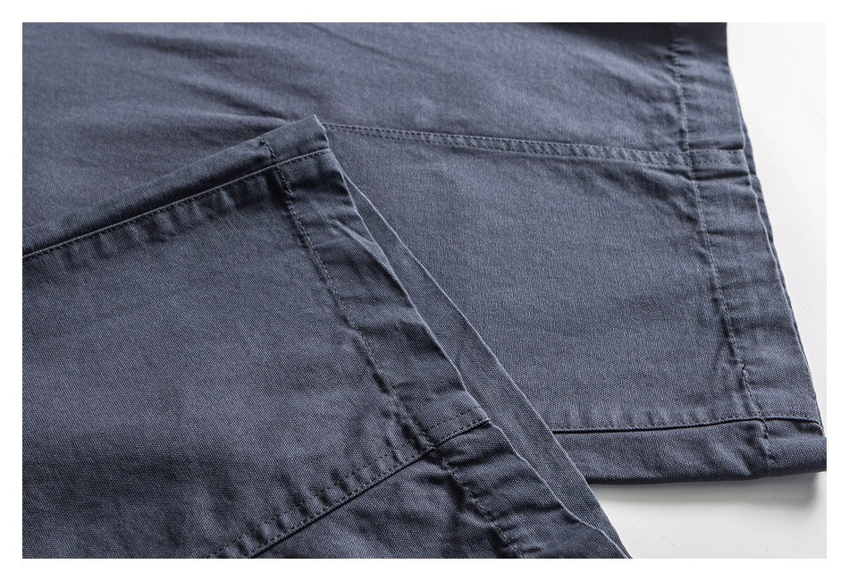 Close-up of slate blue trouser legs showing the stitched hems and fabric texture.