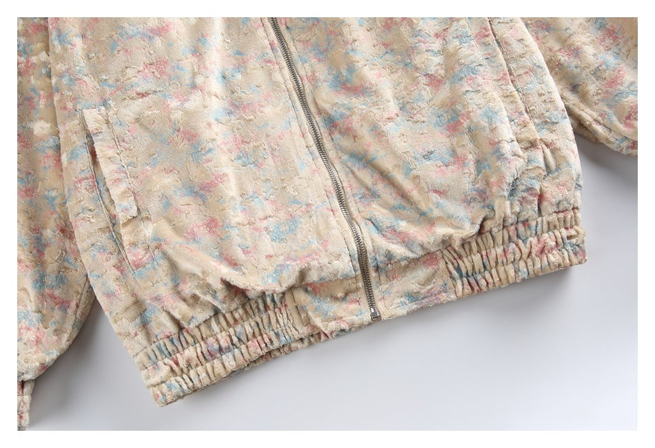 Close-up of the jacket's front zipper, side pocket, and gathered elastic hem in a pastel pattern.