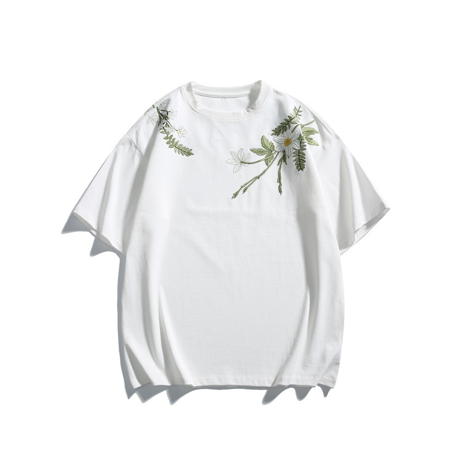White short-sleeve crew-neck T-shirt with green leaf and flower embroidery on the shoulders, front view