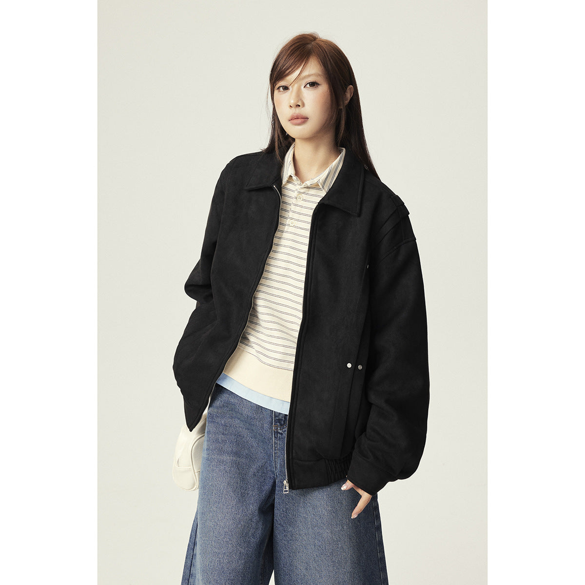 Model wearing an oversized black zip-front jacket with a pointed collar and gathered hem.