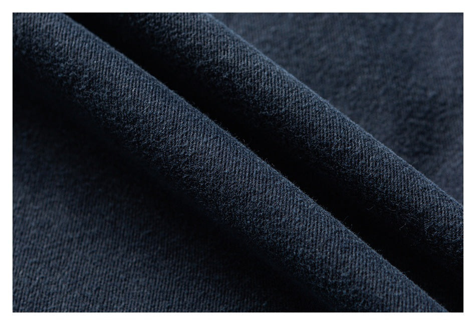 Macro view of dark navy textured fabric arranged in soft folds.