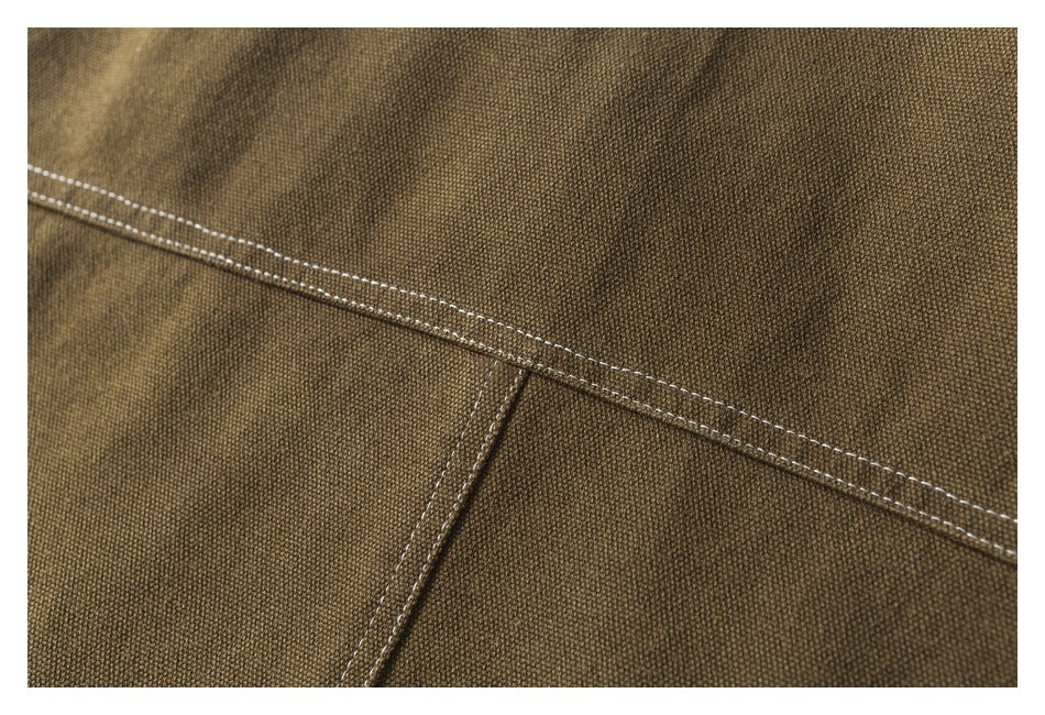 Close-up of brown jacket fabric and intersecting double-stitched seams.