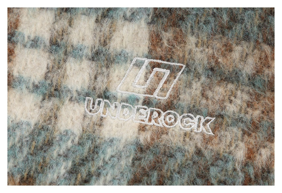 White UNDEROCK embroidery on fuzzy blue-gray, cream, and brown checked fabric.