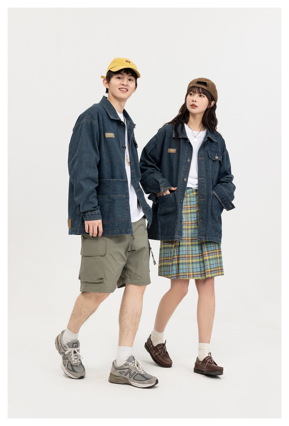 Two models wear dark blue denim chore jackets with patch pockets, shown standing in a studio.
