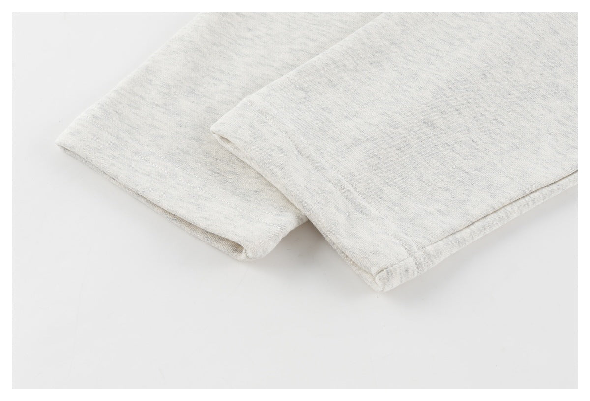 Close-up of the stitched hem on light gray fabric.