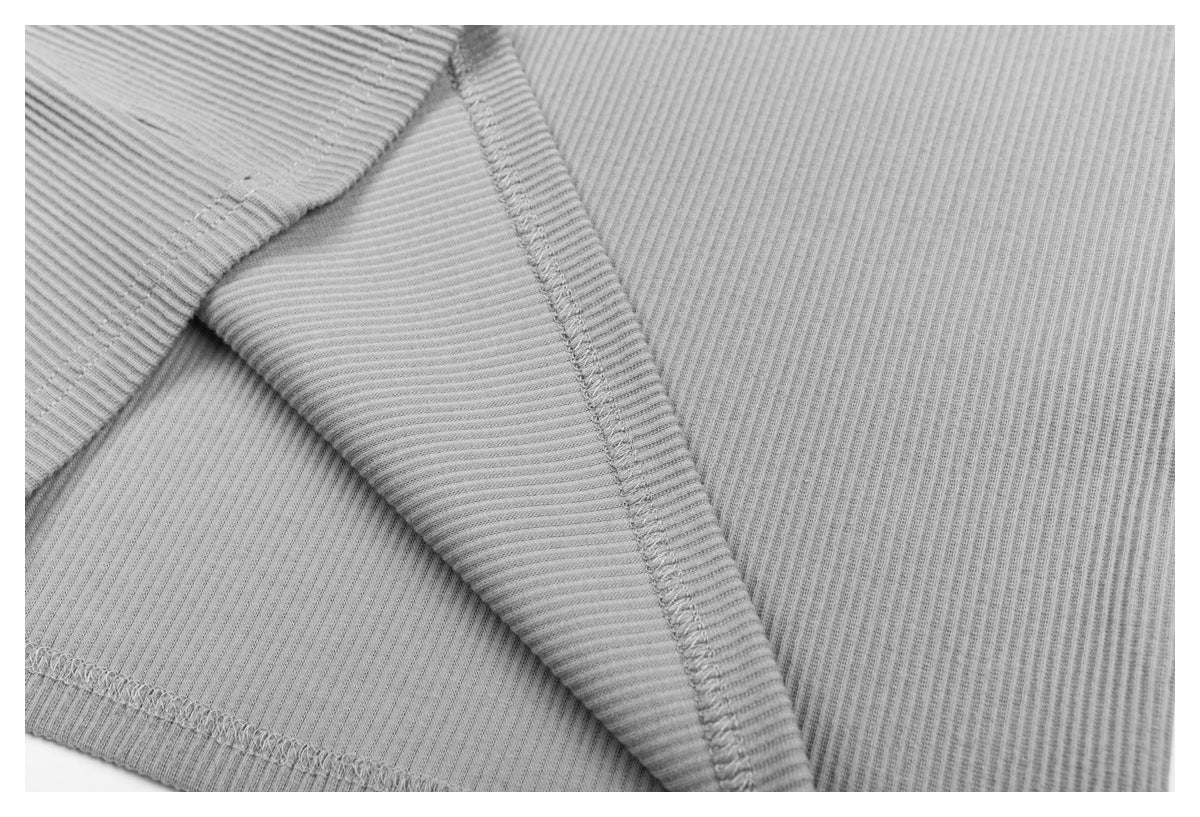 Close-up of the light gray ribbed top's folded edge and overlocked stitching.