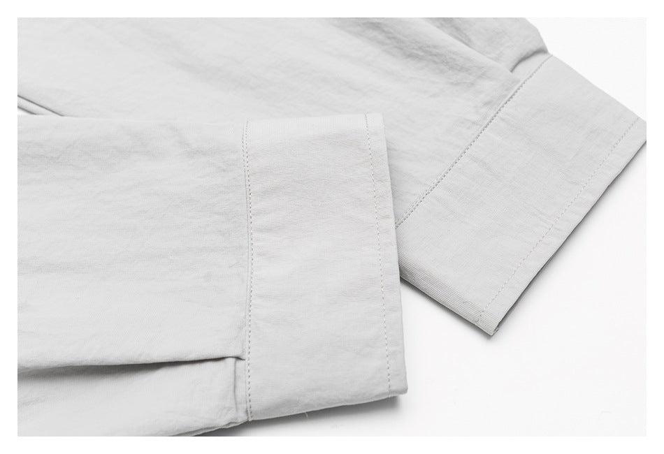Close-up of a light gray garment sleeve showing a wide cuff and neat stitching.