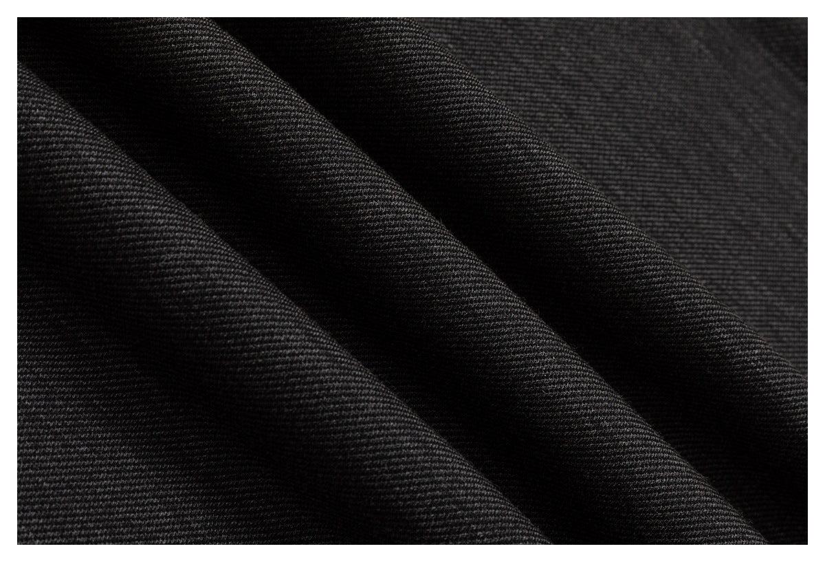 Macro view of dark fabric draped in folds, showing its fine textured weave.