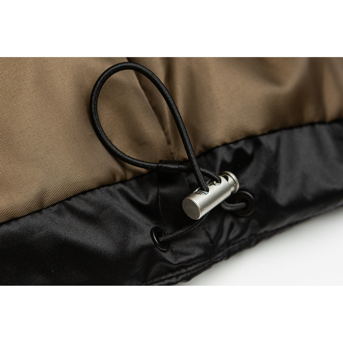 Close-up of the black jacket hem with an adjustable elastic drawcord and metal toggle.