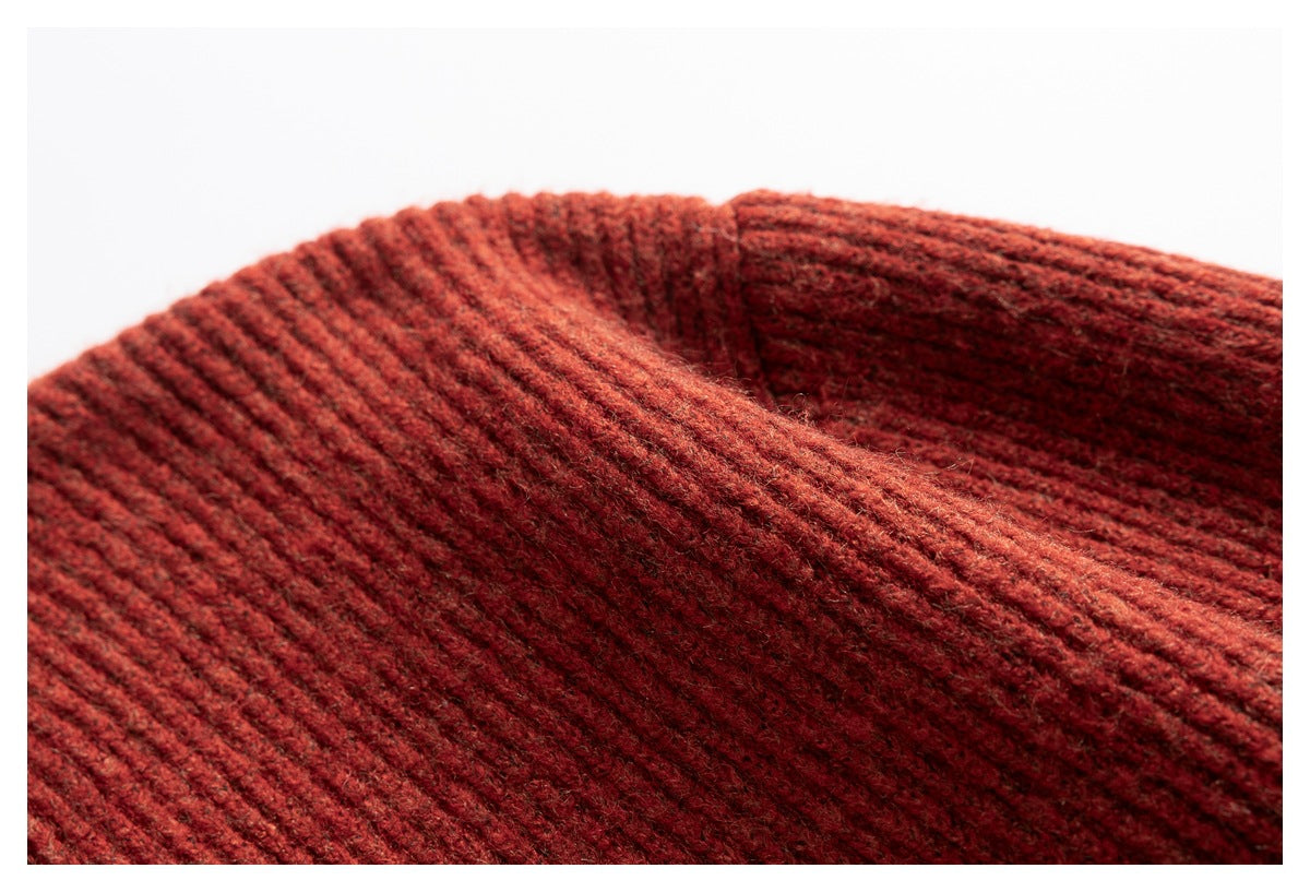 Close-up showing the ribbed knit texture and folded edge of the rust-red sweater collar.