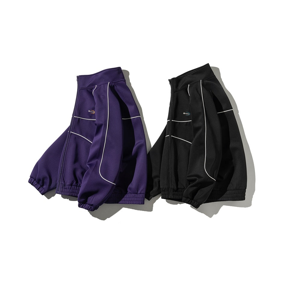 Angled view of purple and black zip-up track jackets showing their sleeves, white piping, and elastic hems.