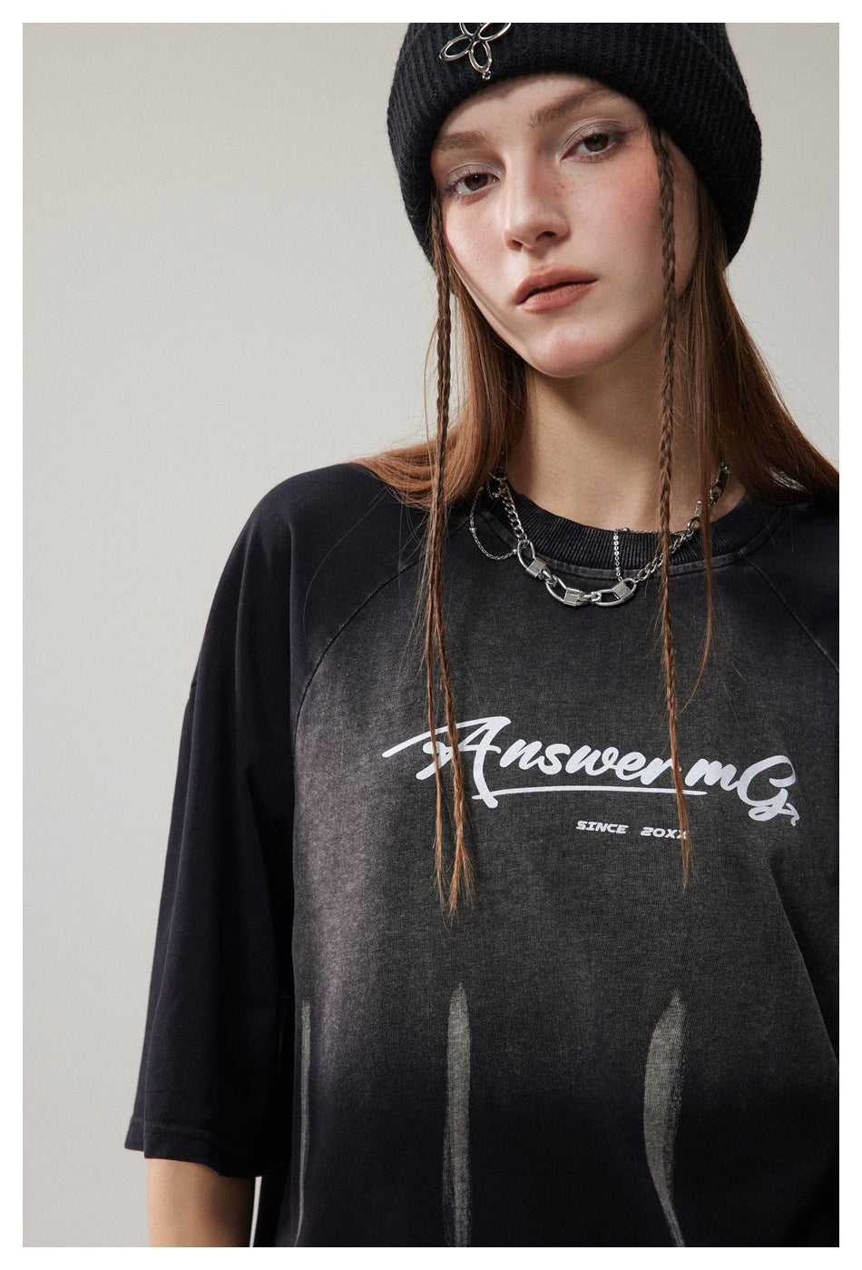 Close-up of a model in a black T-shirt with a faded chest graphic and white script lettering.