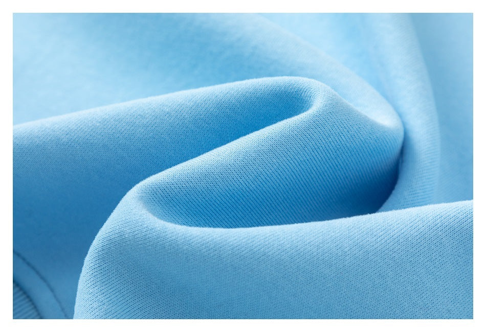 Macro view of light blue garment fabric folded to show its fine surface texture.