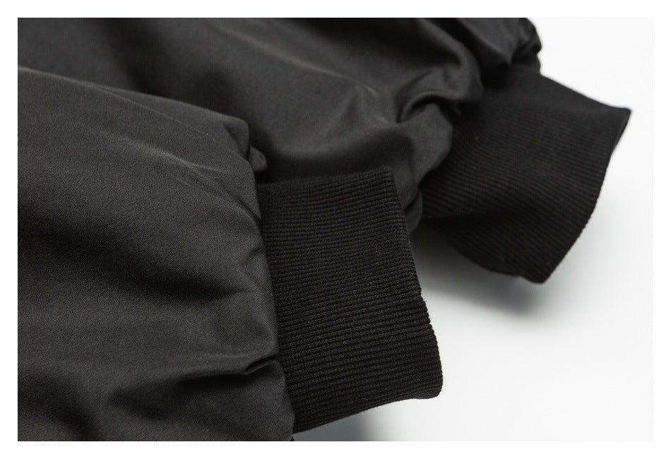 Close-up of a black jacket sleeve with a wide ribbed cuff.
