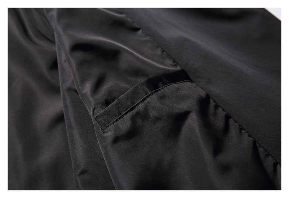 Close-up of a black garment interior seam and narrow stitched pocket opening.