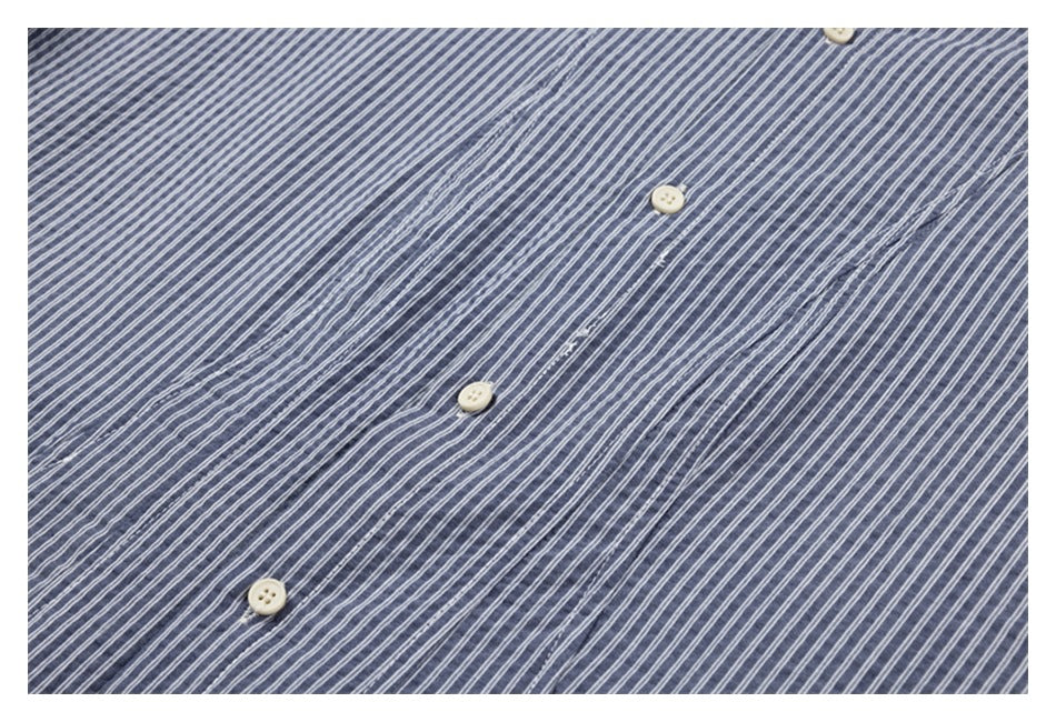 Close-up of the blue-gray shirt's white-striped button placket with cream buttons.