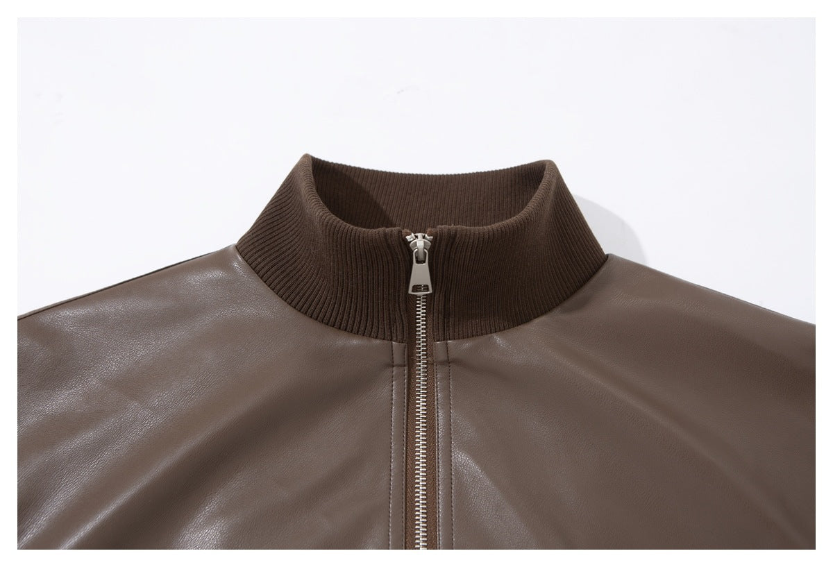 Close-up of a taupe-brown jacket front with a dark brown ribbed stand collar and silver zipper.