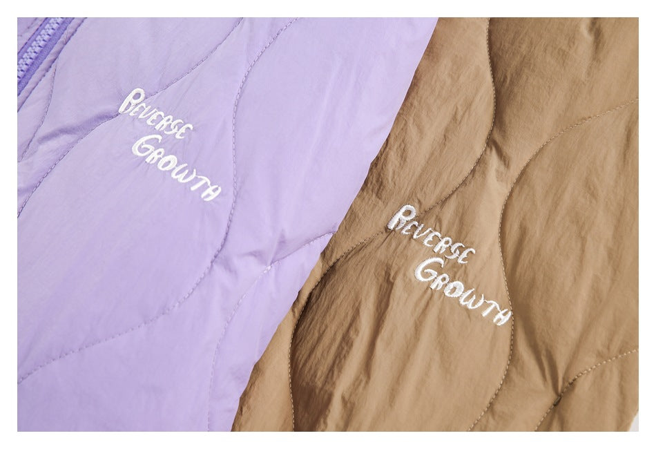 Close-up of lavender and tan quilted jacket fabric, both embroidered with white script.